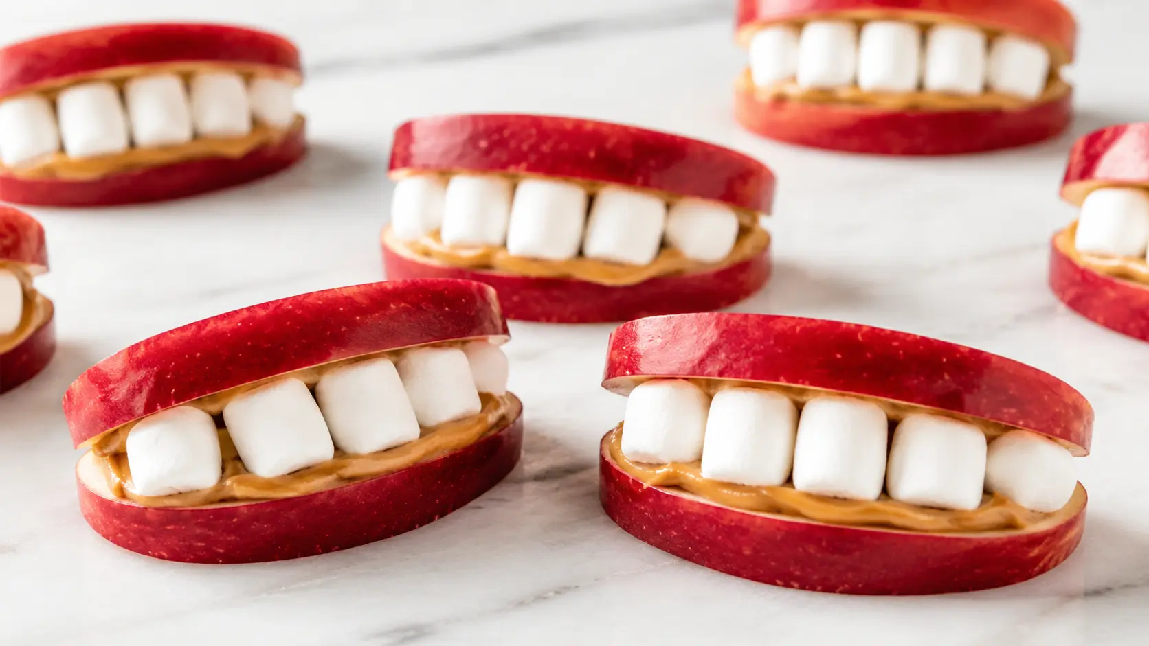Easy apple monster mouths for Halloween made with apple slices, peanut butter, and mini marshmallows