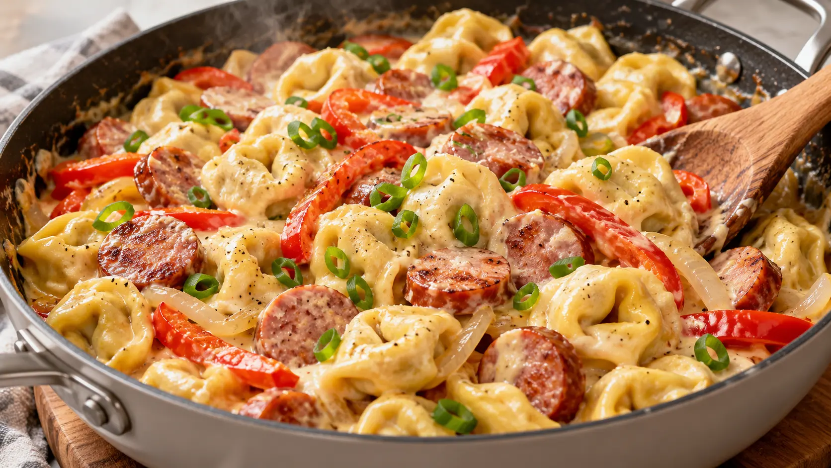 Creamy sausage tortellini skillet with cheese tortellini, browned kielbasa, red bell pepper, onion, and Parmesan cream sauce.